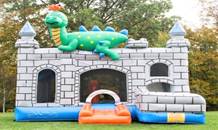 A inflatable castle with a dragon on topDescription automatically generated