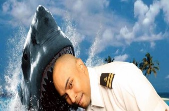 A person in uniform with a shark head  Description automatically generated